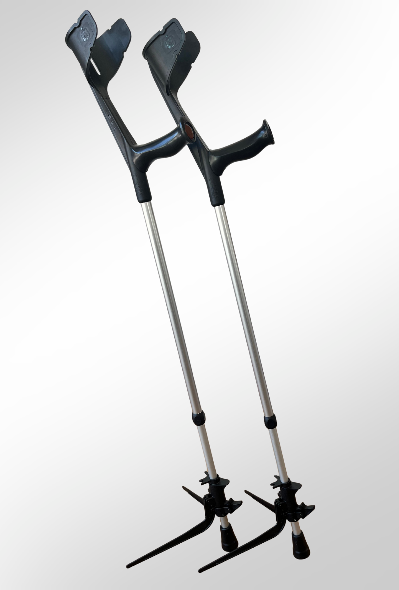 Zwei Unterarmgehstützen stehen mit zwei KrückenBuddys frei im Raum ohne umzufallen